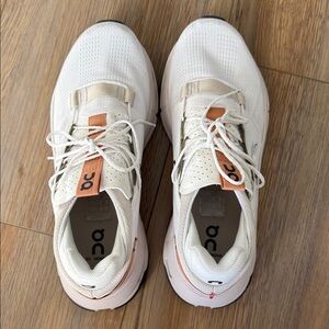 On Running White and Orange Athletic Shoes